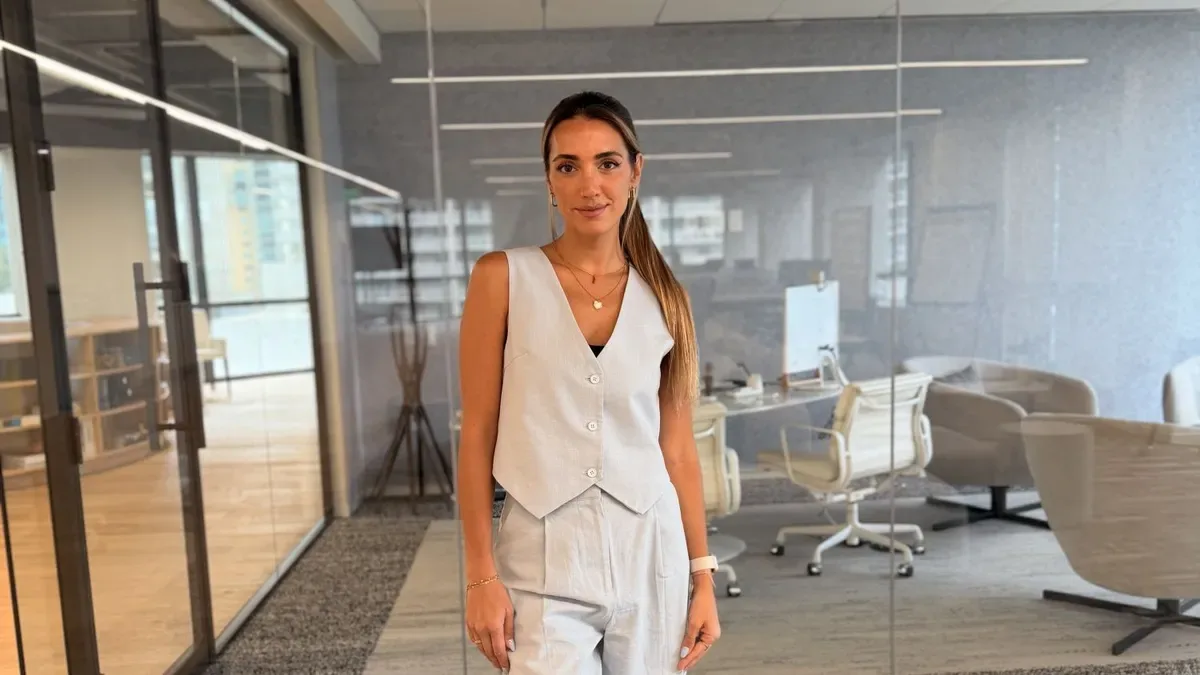 Camila Del Coco en una entrevista en un estudio moderno con fondo de Miami skyline