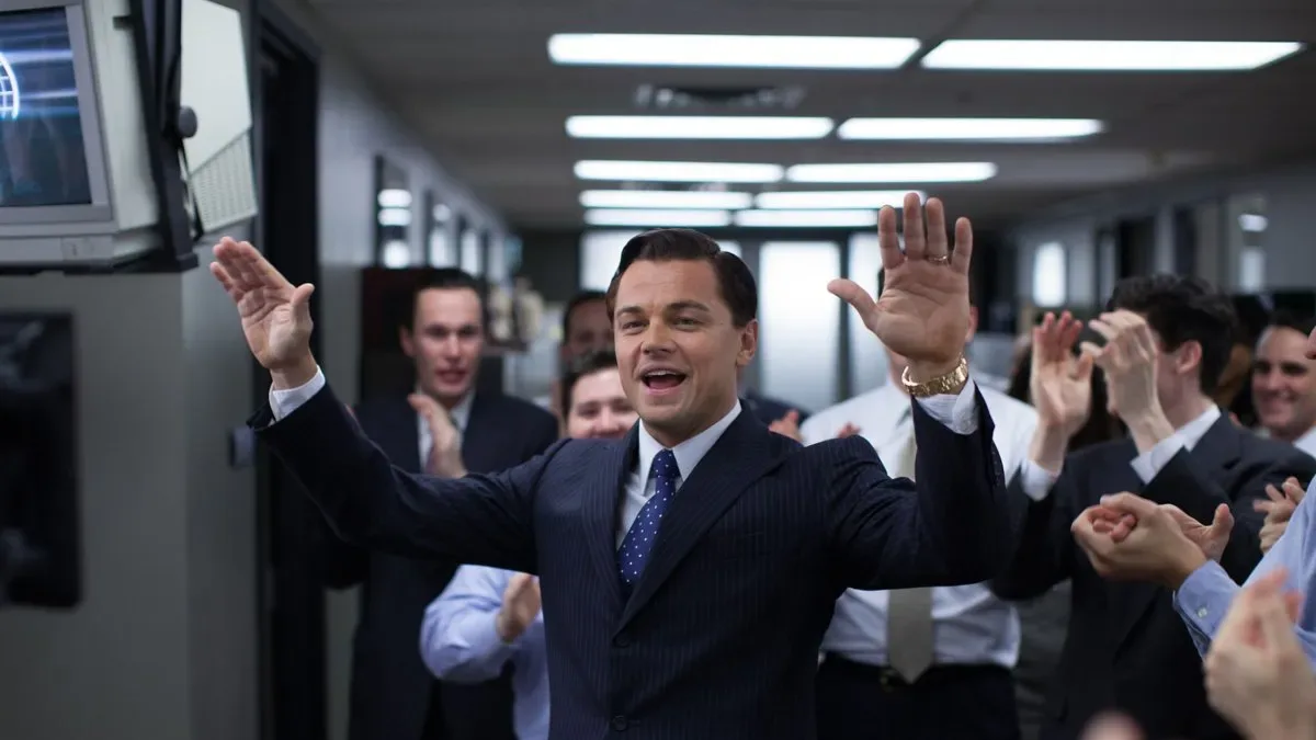 Jordan Belfort hablando en un escenario de conferencia con micrófono