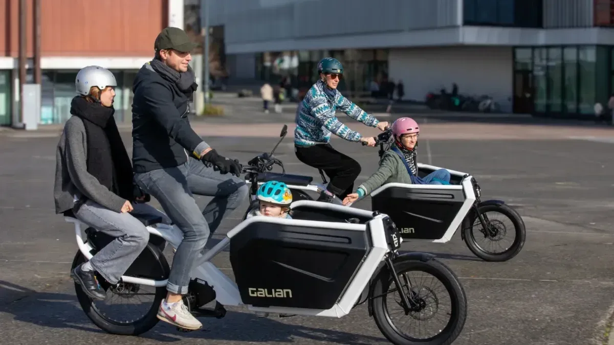 Bicicleta eléctrica de carga con asiento para cuatro personas en calle urbana