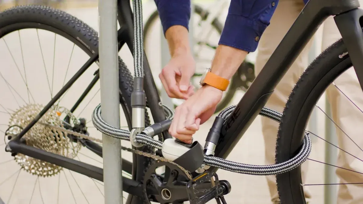 Candado innovador asegurando cuadro, ruedas y accesorios de una bicicleta urbana en la calle