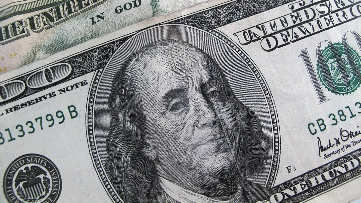 Billetes de dólar blue apilados sobre un gráfico de cotización ascendente