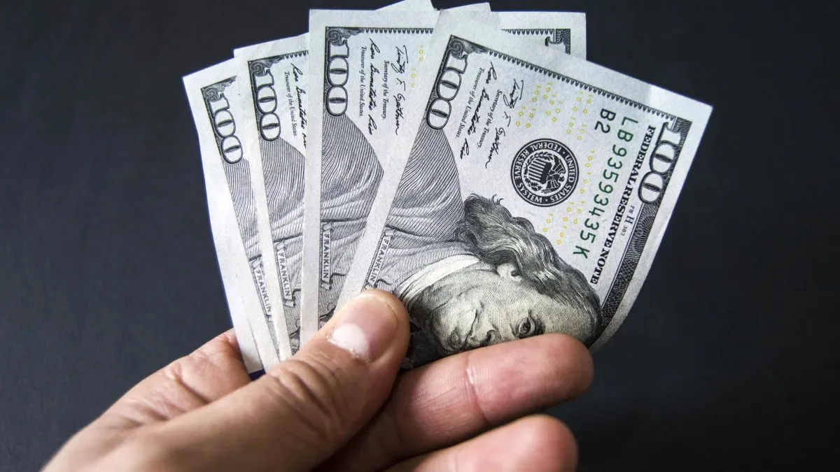 Gráfico del dólar oficial con tendencia alcista y billetes de pesos argentinos