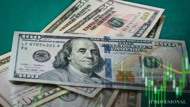 Billetes de dólar estadounidense apilados sobre una mesa con cotizaciones cambiarias de fondo