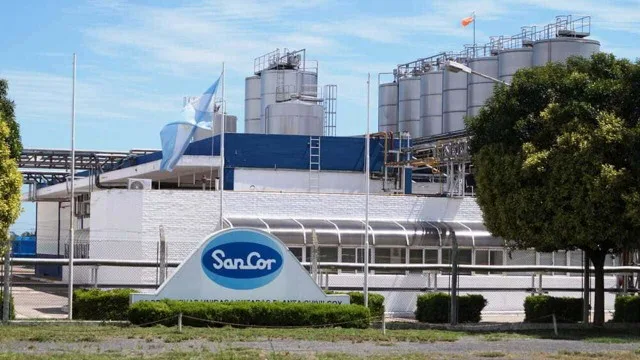 Instalaciones industriales de SanCor con tanques de leche y logos visibles en la planta