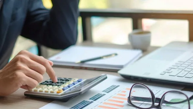 Contador revisando balances y documentos fiscales en su escritorio