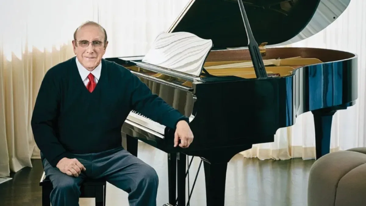 Clive Davis junto a Whitney Houston en una gala de premios, sonriendo en el escenario