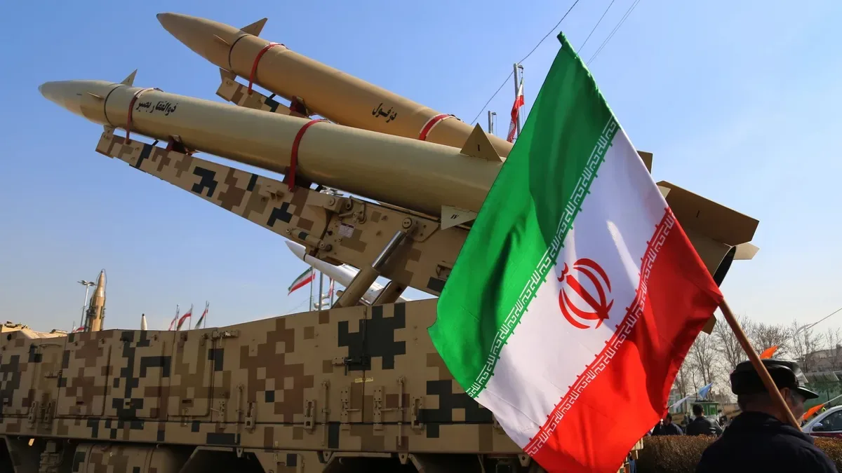 Bandera iraní ondeando junto a un misil balístico en desfile militar en Teherán