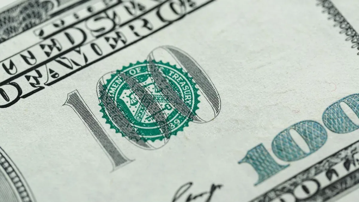 Billetes de dólares apilados y cotizaciones en pantallas de cambio en Buenos Aires