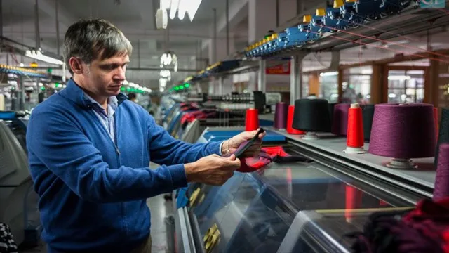 Fábrica textil argentina con máquinas detenidas y poca iluminación