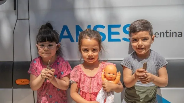 Mujer con niño pequeño revisando documentos de ANSES en una oficina