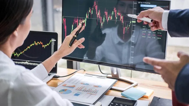 Inversor principiante revisando gráficos de bolsa en su computadora con expresión de preocupación