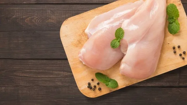 Pollo asado en fuente junto a cortes de carne vacuna en una mesa familiar argentina