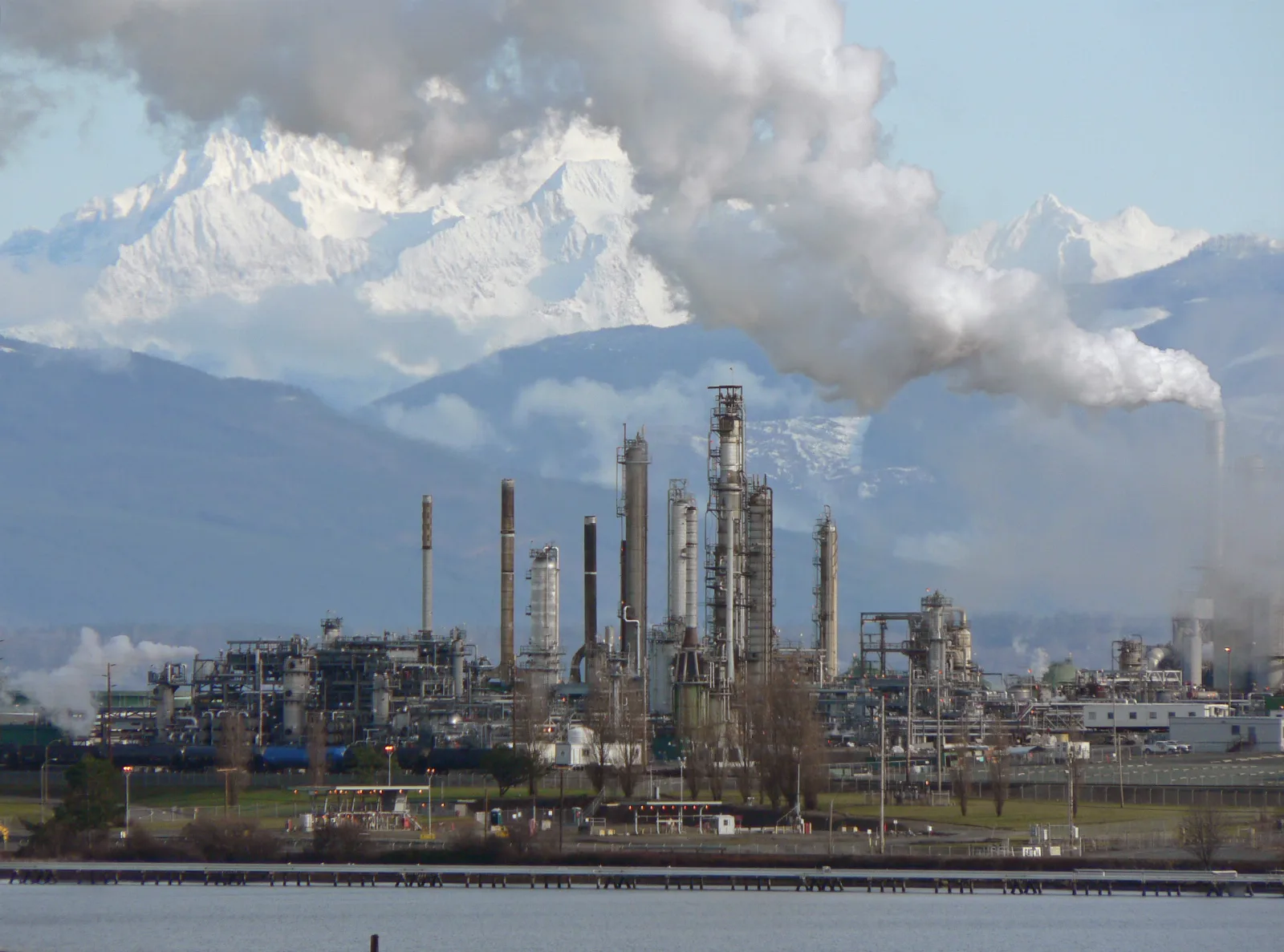 Refinería de petróleo con torres de destilación y tanques de almacenamiento, símbolo de la industria del crudo