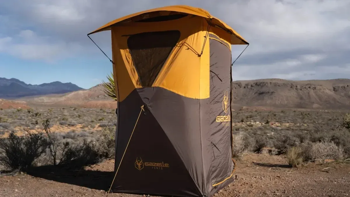 Cabina portátil sanitaria plegable armándose en un camping al aire libre