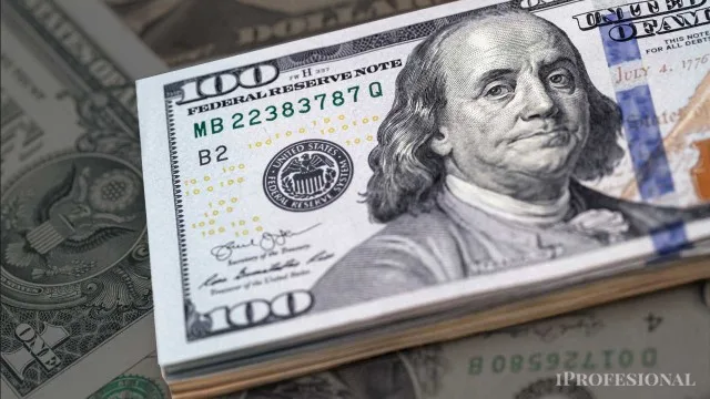 Billetes de dólares apilados sobre un gráfico de cotización con flechas descendentes