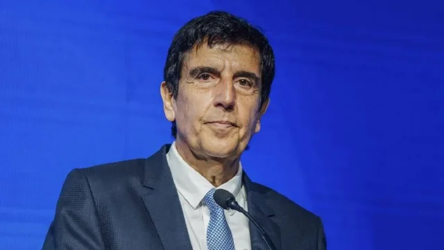 Carlos Melconian en una conferencia económica con gráficos de fondo
