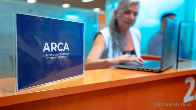 Persona revisando documentos fiscales en computadora con logo de ARCA visible
