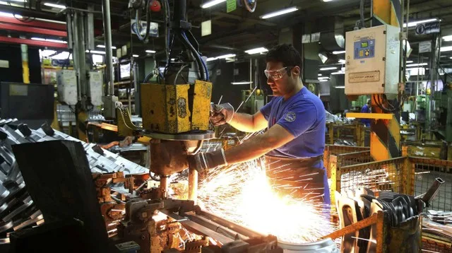 Empresarios pymes en una fábrica argentina analizando documentos y balances financieros