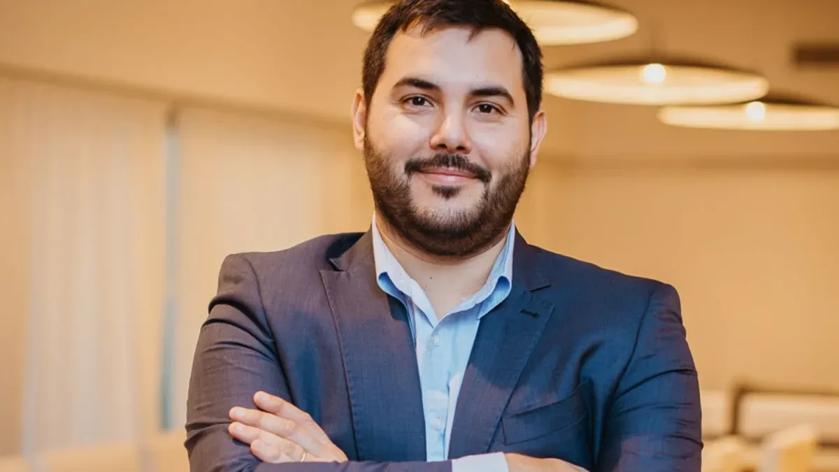 Lautaro Carmona, CEO de Unitech, en una oficina moderna con pantallas de inteligencia artificial