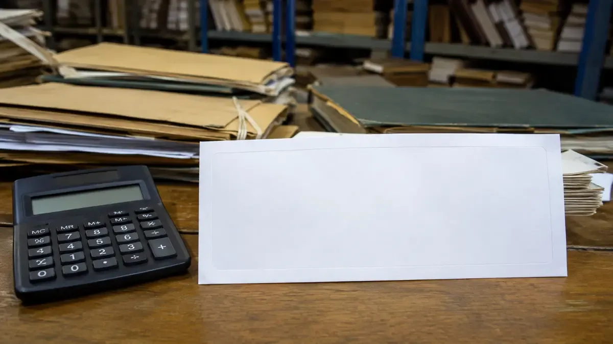 Un recibo salarial completamente en blanco junto a una calculadora en un archivo administrativo con carpetas lisas, plano medio documental, perspectiva natural